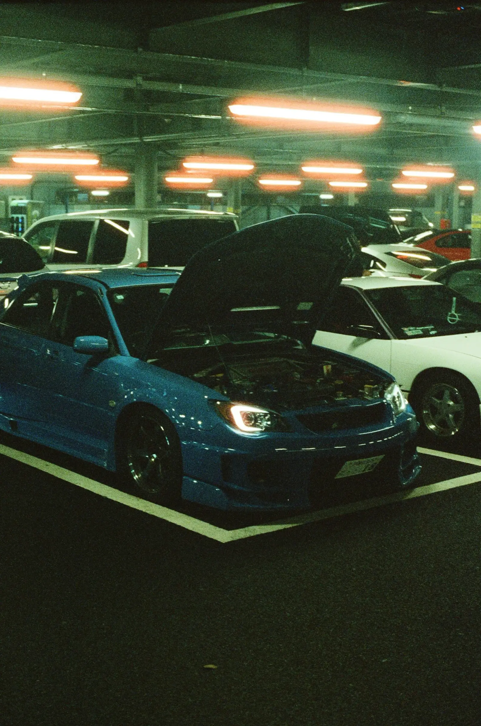 Blue Subaru with its hood open at a meet