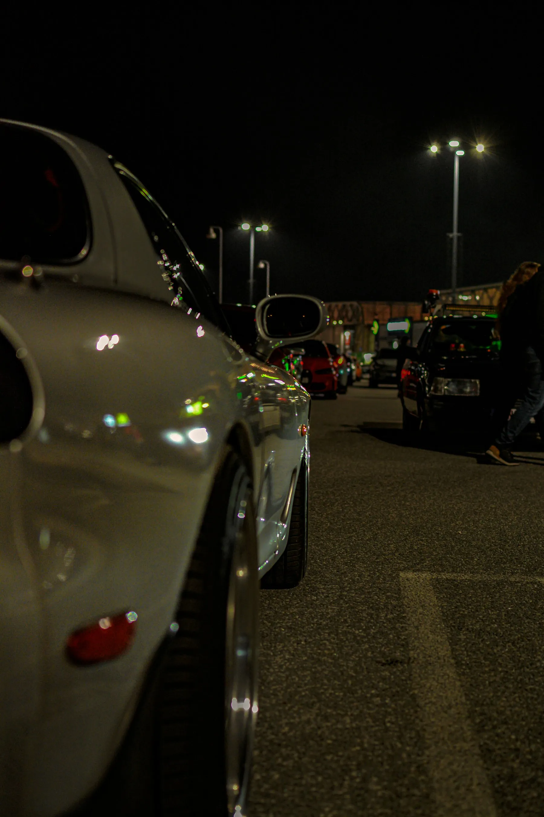 Modified cars parked at night under streetlights